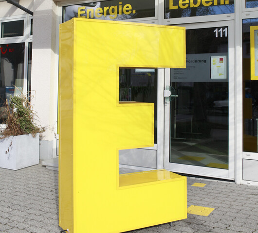 Der Buchstabe E als lebensgroße Form vor dem Stadtteilbüro. 